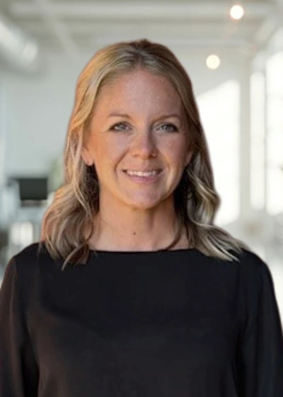 Lindsay DeGabriele, dressed in a black shirt, stands in a professional office setting